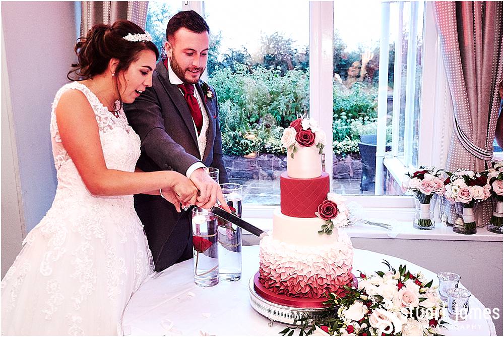 Cake cutting fun for our bride and groom at The Moat House by Stafford Wedding Photographers Stuart James