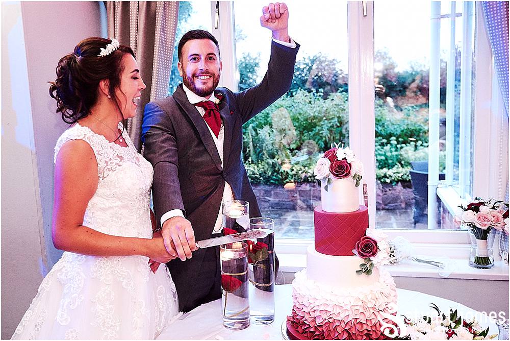 Cake cutting fun for our bride and groom at The Moat House by Stafford Wedding Photographers Stuart James