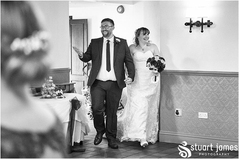 Capturing the entrance of the bride and groom to their waiting guests at Oak Farm Hotel in Cannock - Oak Farm Wedding Photographs by Stuart James