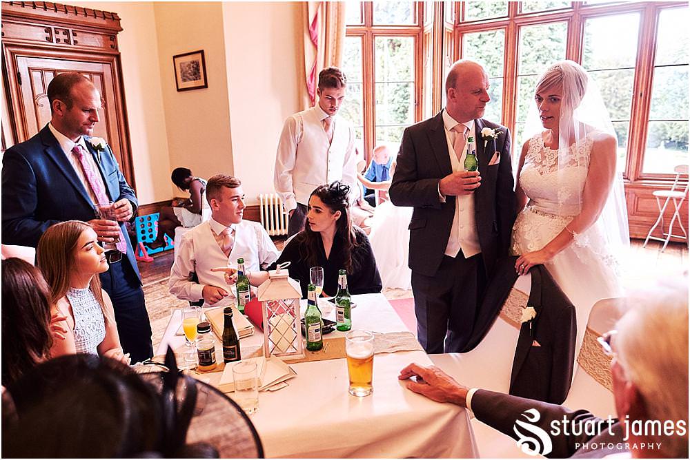 Creative candid photographs as the guests enjoy the drinks reception sheltering from the rain at Hawkesyard Estate - Hawkesyard Wedding Photographs by Stuart James