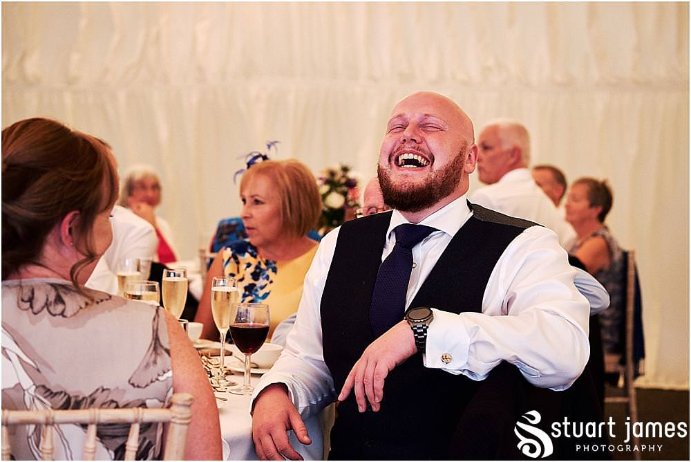 Creative candid photos as the guests relax and enjoy the wedding breakfast in the marquee at Heath House in Tean by Heath House Wedding Photographers Stuart James