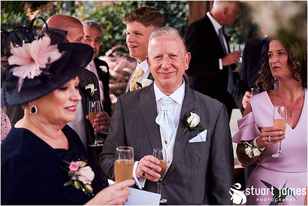 Creative candid photos of the guests greeting the new Mr & Mrs at The Moat House in Acton Trussell - Recommended Stafford Wedding Photographers Stuart James