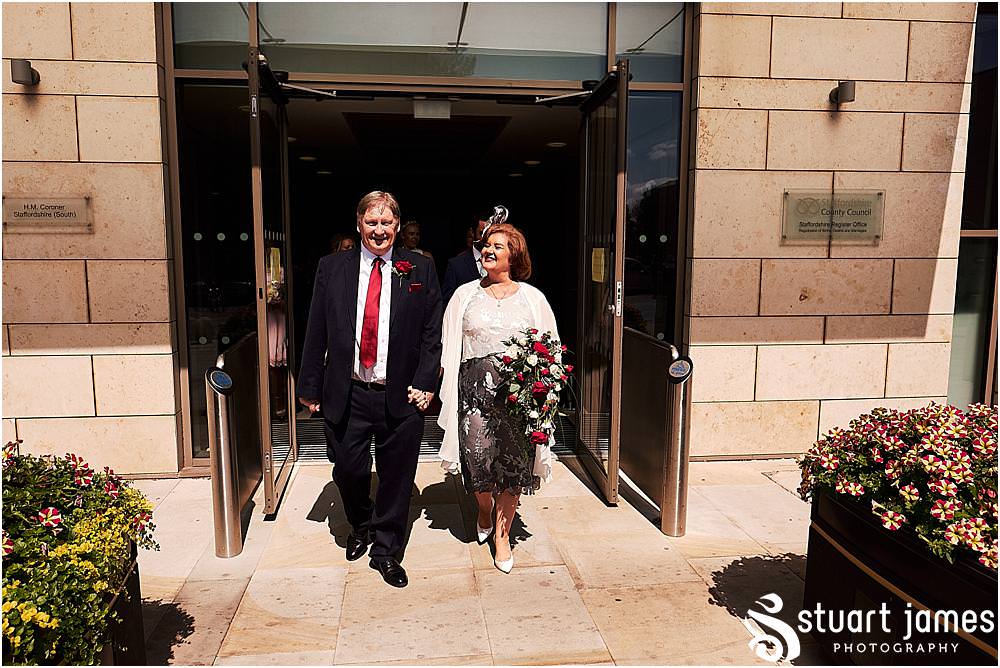 Creative candid photographs of the guests greeting the new Mr & Mrs at Stafford Registry Office in Stafford by Stafford Registry Office Wedding Photographers Stuart James