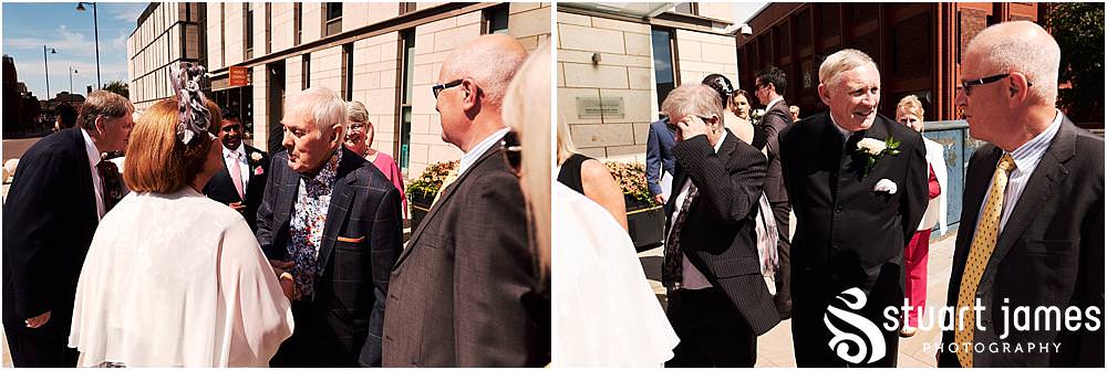 Creative candid photographs of the guests greeting the new Mr & Mrs at Stafford Registry Office in Stafford by Stafford Registry Office Wedding Photographers Stuart James