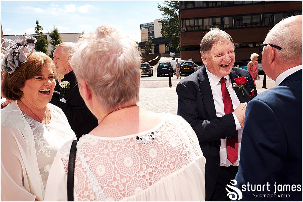 Creative candid photographs of the guests greeting the new Mr & Mrs at Stafford Registry Office in Stafford by Stafford Registry Office Wedding Photographers Stuart James