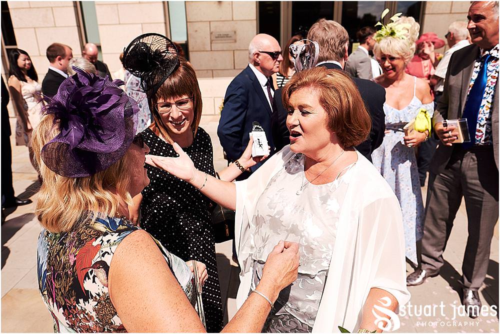 Creative candid photographs of the guests greeting the new Mr & Mrs at Stafford Registry Office in Stafford by Stafford Registry Office Wedding Photographers Stuart James