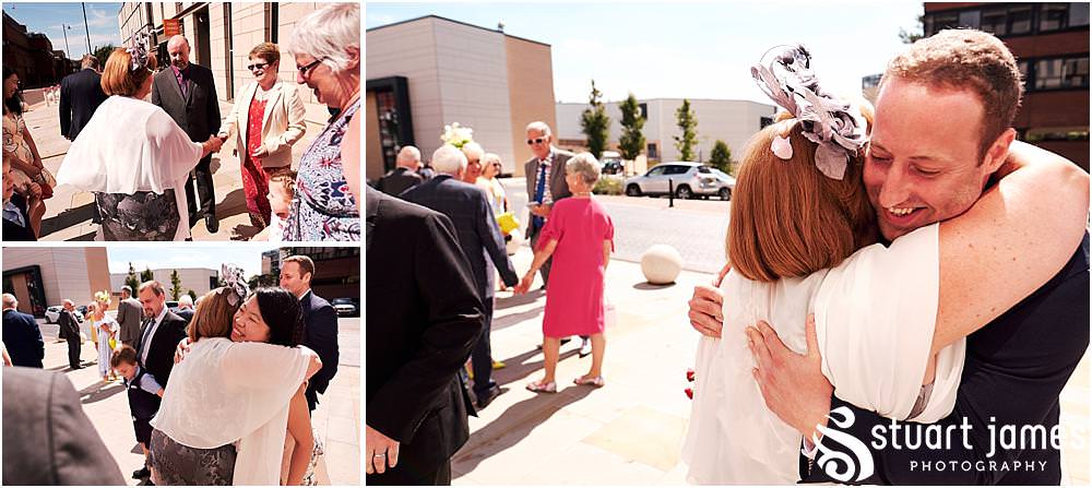 Creative candid photographs of the guests greeting the new Mr & Mrs at Stafford Registry Office in Stafford by Stafford Registry Office Wedding Photographers Stuart James
