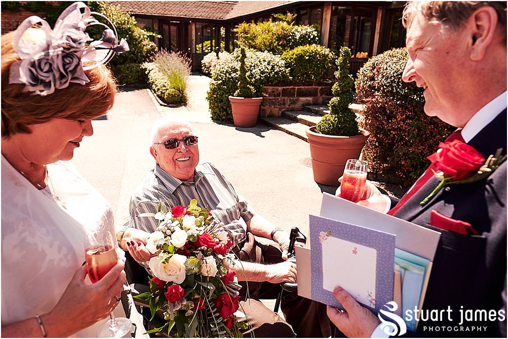 Creative candid photographs of the guests greeting the new Mr & Mrs at Stafford Registry Office in Stafford by Stafford Registry Office Wedding Photographers Stuart James