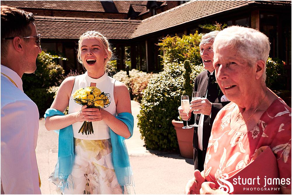 Creative candid photographs of the guests greeting the new Mr & Mrs at Stafford Registry Office in Stafford by Stafford Registry Office Wedding Photographers Stuart James