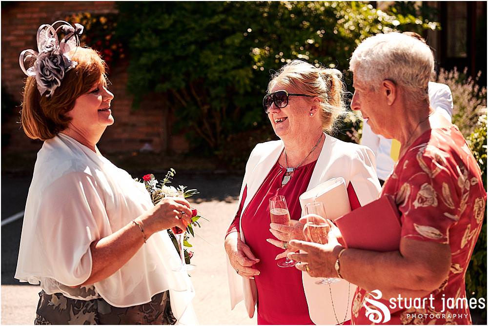 Creative candid photographs of the guests greeting the new Mr & Mrs at Stafford Registry Office in Stafford by Stafford Registry Office Wedding Photographers Stuart James