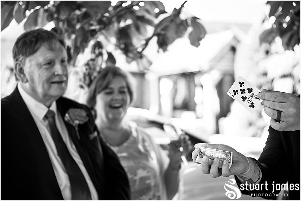 Capturing the reactions of the guests to the close up magician at The Moat House in Stafford - Stafford Registry Office Wedding Photographers Stuart James