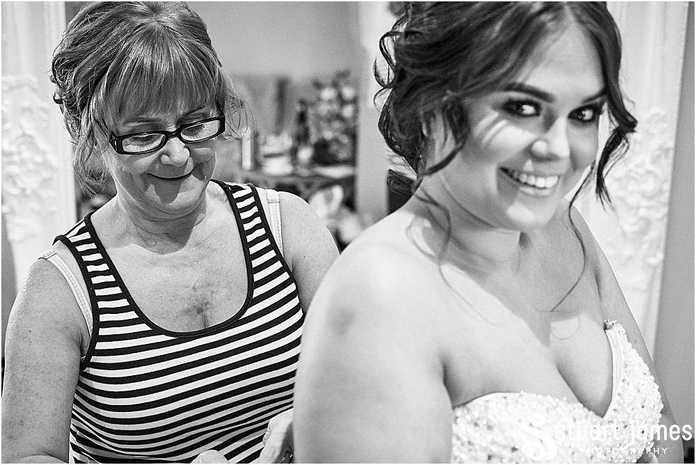 Mother of the bride helping tie the bride's wedding dress from Lucy Alexander Bridal, photo by Stuart James Photography at Aston Marina, Stone