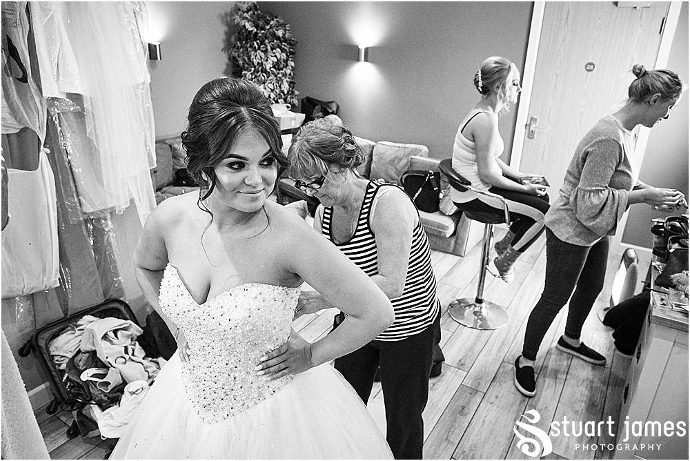 Mother of the bride helping tie the bride's wedding dress from Lucy Alexander Bridal, photo by Stuart James Photography at Aston Marina, Stone