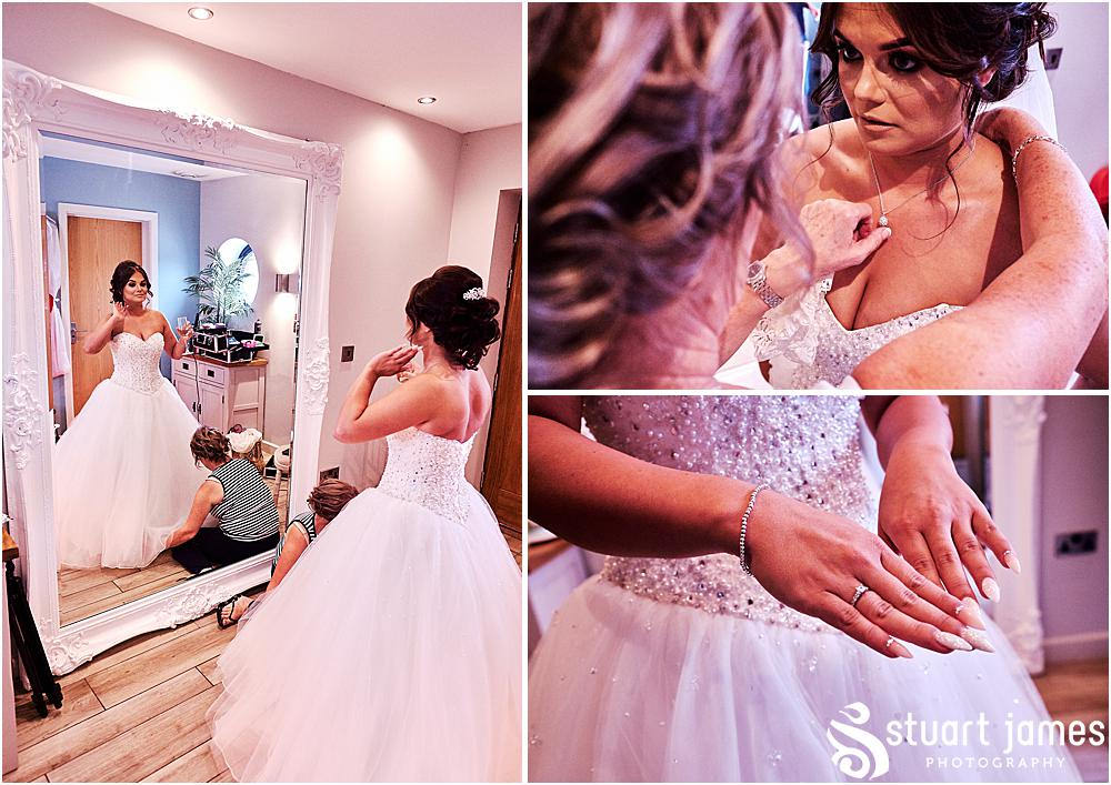 Staffordshire bride looks at her wedding dress from Lucy Alexander Bridal and jewelry in mirror, photo by Stuart James Photography at Aston Marina, Stone