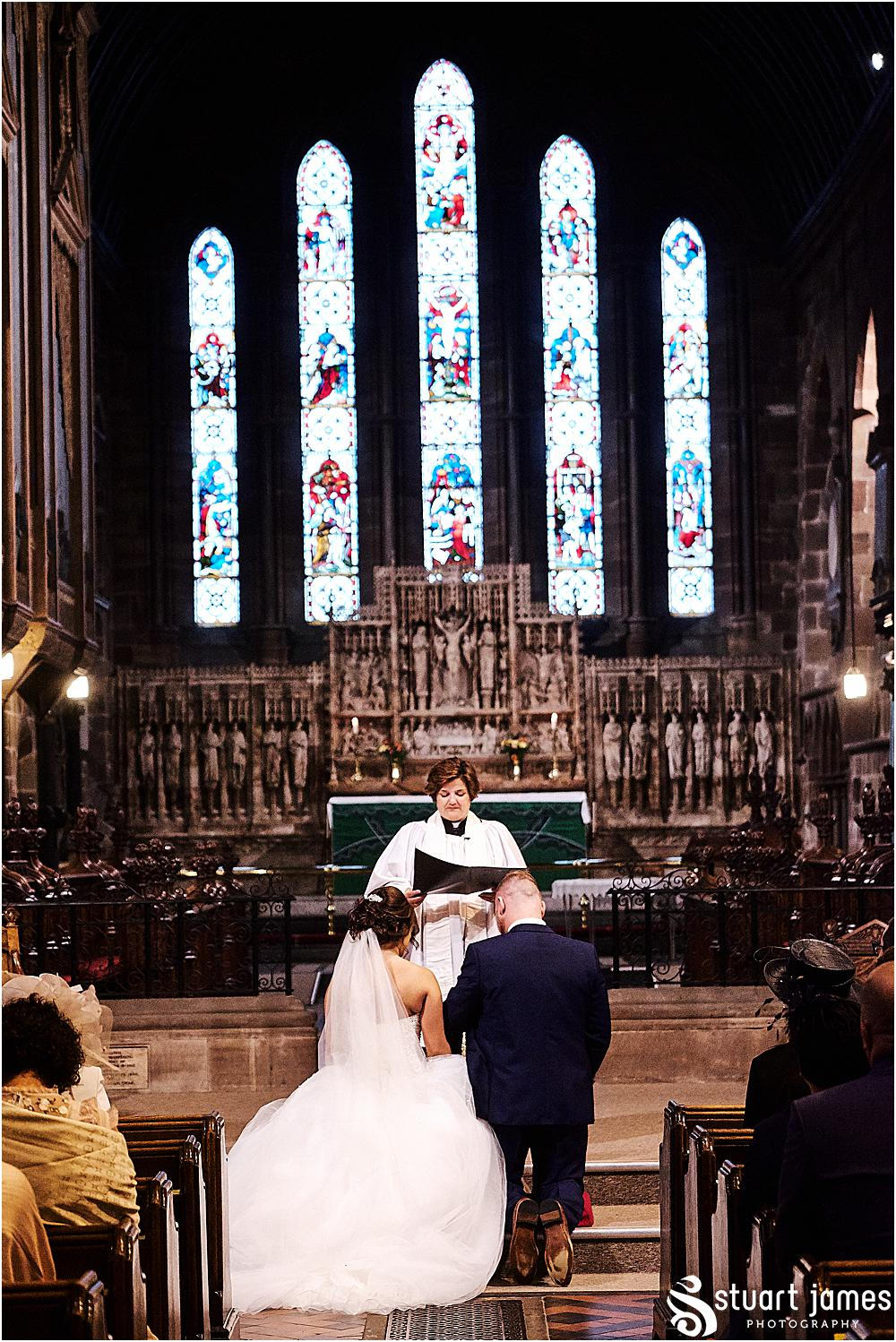 Bride and Groom kneeling at the altar in Chruch, photo by Stuart James Photography at Holy Trinity, Eccleshall