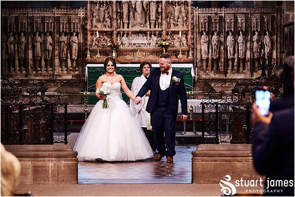 Bride and Groom leave the church holding hands and walking down the aisle, photo by Stuart James Photography at Holy Trinity, Eccleshall