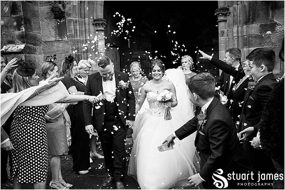 Wedding guests, bridesmaids and ushers throw confetti over married couple, photo by Stuart James Photography at Holy Trinity, Eccleshall