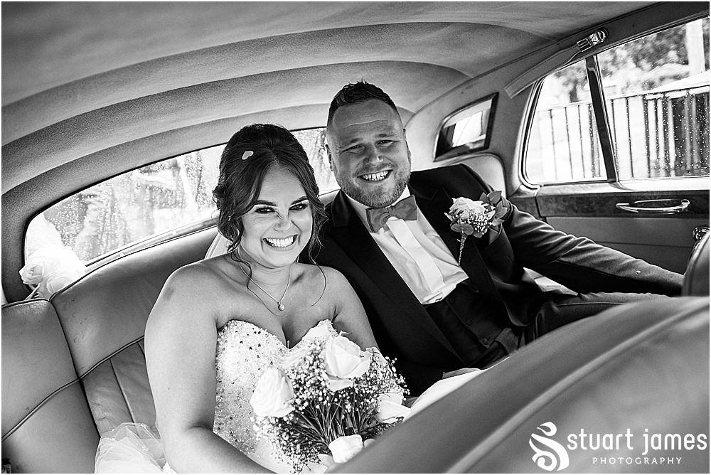 Bride and Groom pose for photo in the back of the wedding car, ready to go their wedding reception as Aston Marina, photo by Stuart James Photography at Holy Trinity, Eccleshall