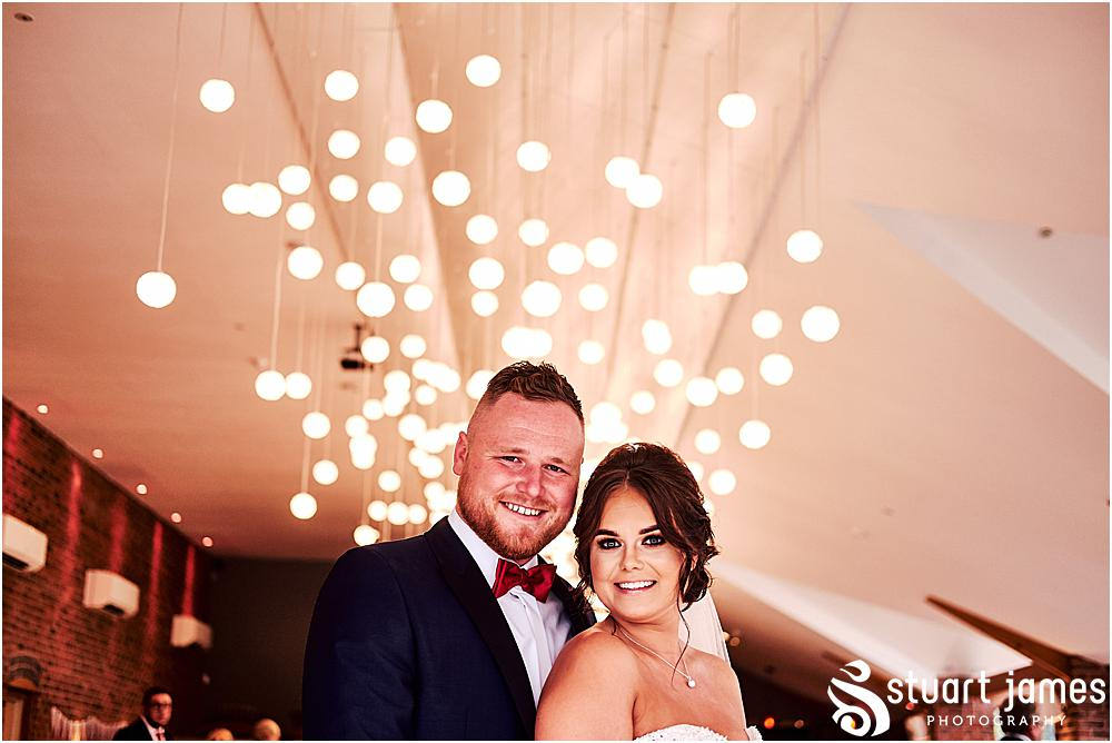 Bride and Groom pose for wedding photograph at wedding reception under fairy lights, photo by Stuart James Photography at Aston Marina, Stone.