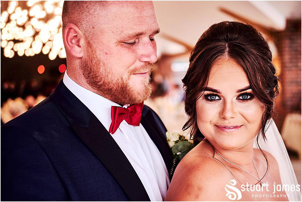 Groom looks at Bride lovingly as they pose for wedding photograph at wedding reception under fairy lights, photo by Stuart James Photography at Aston Marina, Stone.