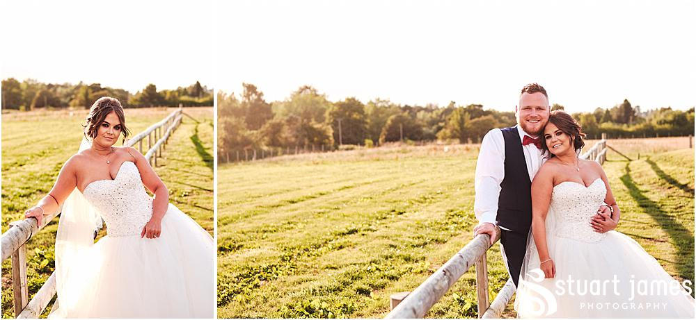 Bride and Groom posing for wedding portrait outside of wedding venue, leaning up fence in a sunny field, photo by Stuart James Photography at Aston Marina, Stone