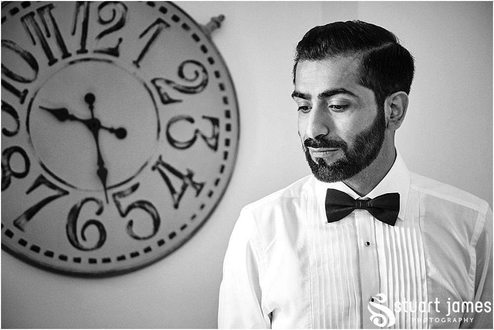 Groom inside portrait with clock on the wall in the background at Davenport House in Shropshire by Davenport House Wedding Photographers Stuart James