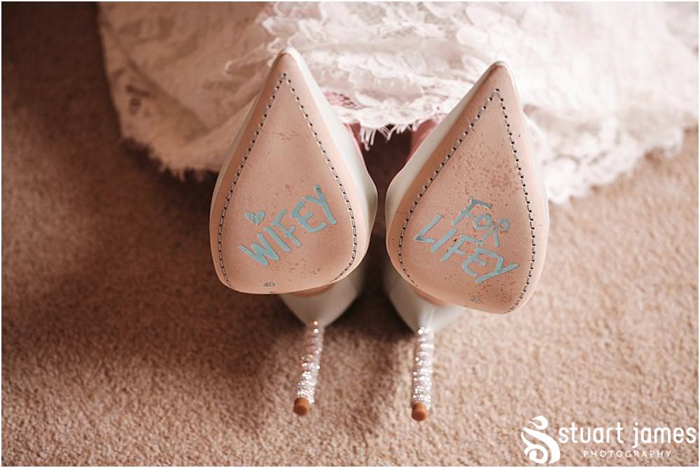 Brides wedding shoes with wifey for lifey inscription on the bottom in blue at Davenport House in Shropshire by Davenport House Wedding Photographers Stuart James