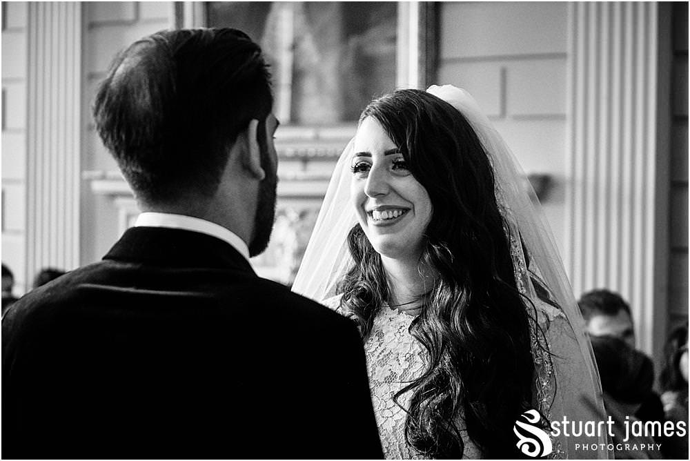 Bride smiles at Groom whilst reciting vows at Davenport House in Shropshire by Davenport House Wedding Photographers Stuart James