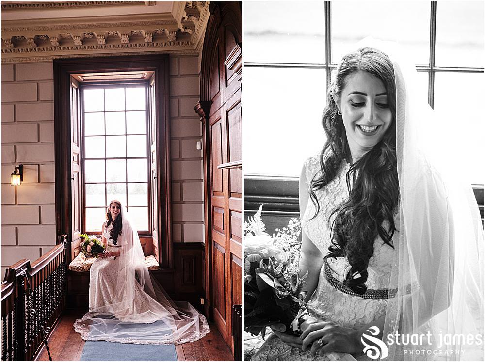 Brides poses for portrait sat at a window seat in front of a big sash window with bouquet and veil at Davenport House in Shropshire by Davenport House Wedding Photographers Stuart James