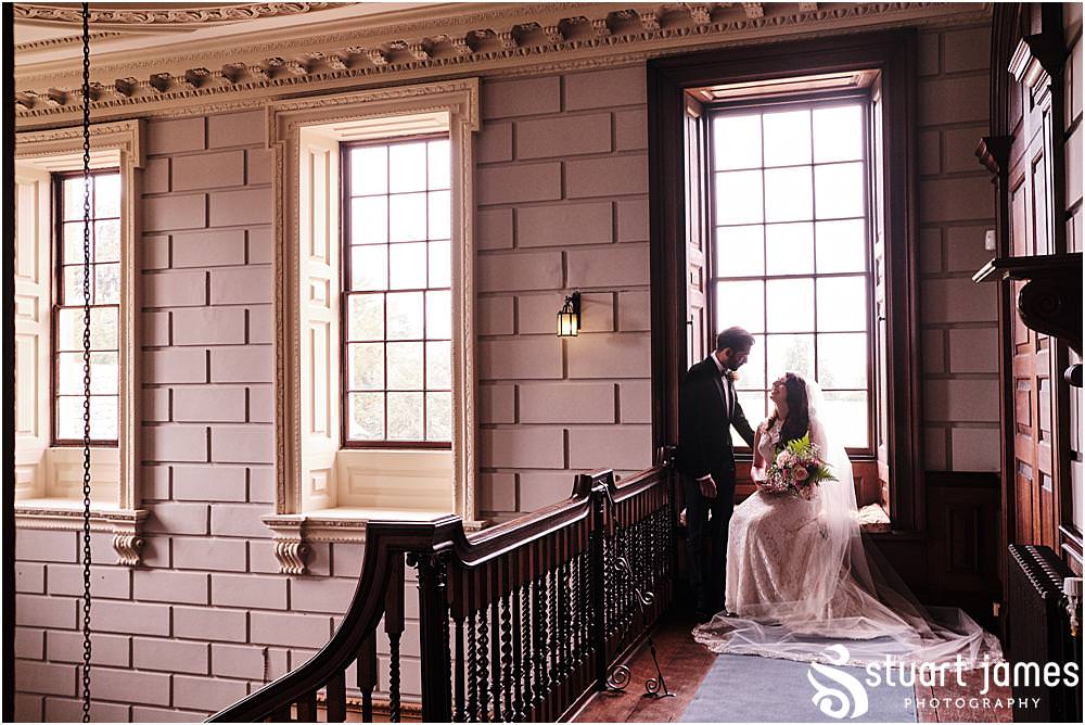 Bride and Groom look at each other for photo in front of a sash window at Davenport House in Shropshire by Davenport House Wedding Photographers Stuart James