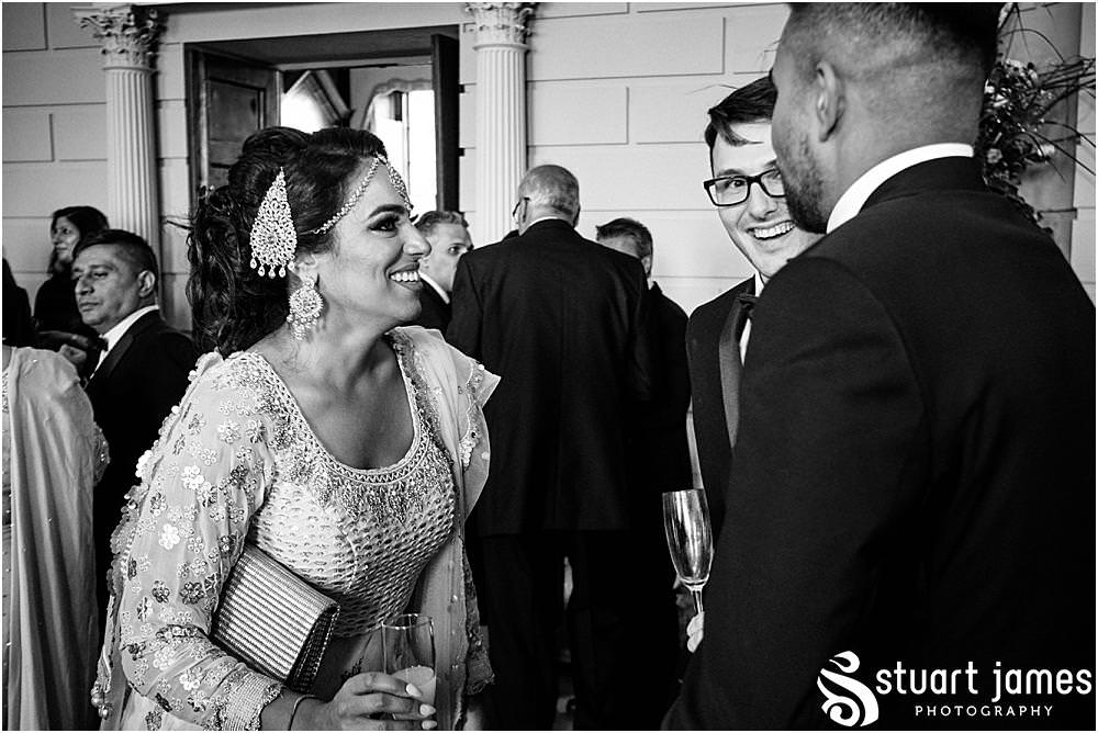 Wedding guests talk and laugh at Davenport House in Shropshire by Davenport House Wedding Photographers Stuart James