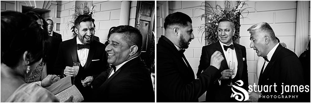 Groomsmen talk and laugh with each other at Davenport House in Shropshire by Davenport House Wedding Photographers Stuart James