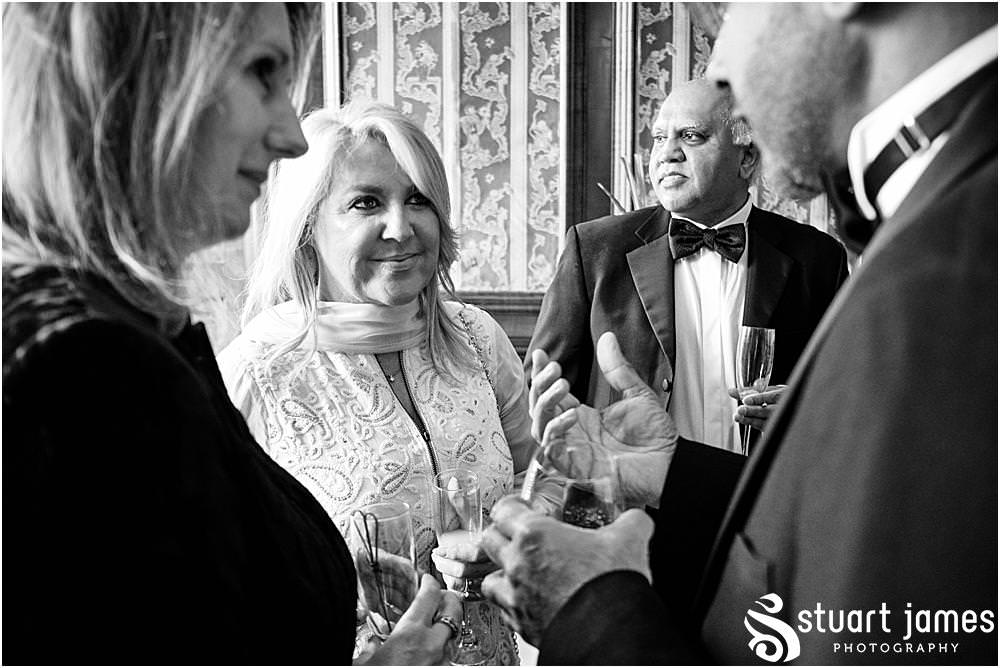 Wedding guests talk and drink at Davenport House in Shropshire by Davenport House Wedding Photographers Stuart James