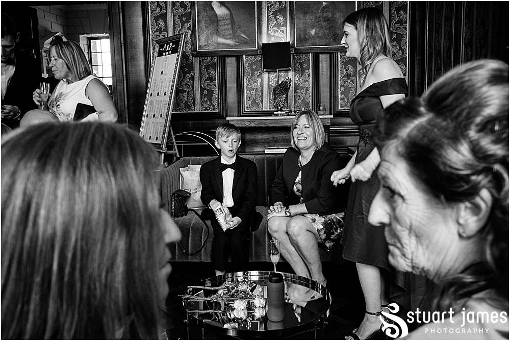 Wedding guests sit and talk in room at Davenport House in Shropshire by Davenport House Wedding Photographers Stuart James