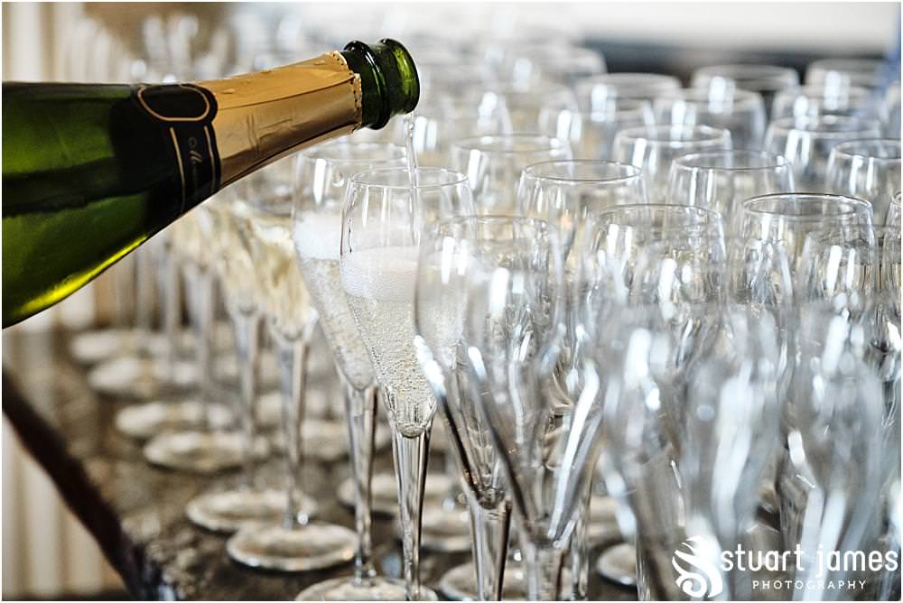 Bottle of champagne being poured into champagne glasses at Davenport House in Shropshire by Davenport House Wedding Photographers Stuart James
