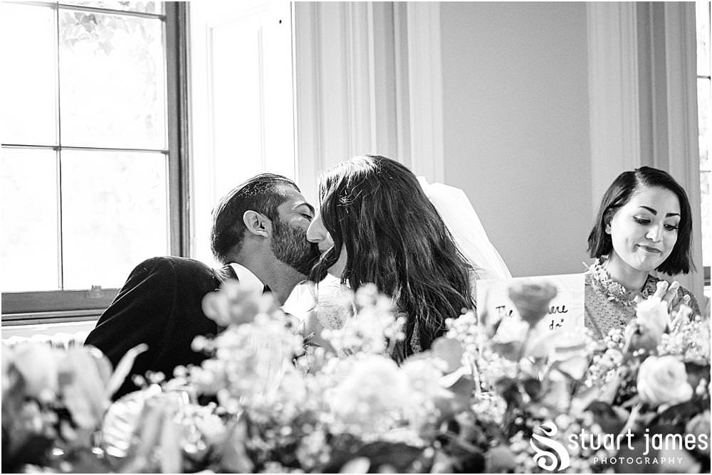 Bride and Groom kiss at the top table at Davenport House in Shropshire by Davenport House Wedding Photographers Stuart James