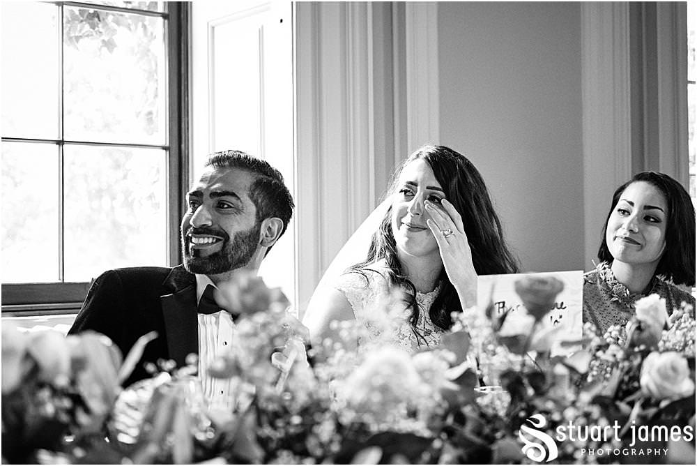 Groom smiles and Bride get emotional listening to speech at the top table at Davenport House in Shropshire by Davenport House Wedding Photographers Stuart James