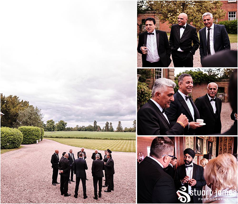 Groom's men stand outside and talk at Davenport House in Shropshire by Davenport House Wedding Photographers Stuart James