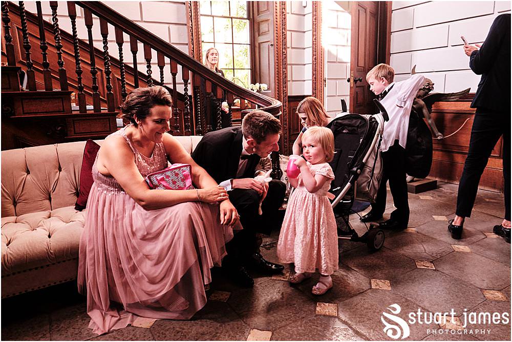 Bridesmaid and flower girl with guests talk at Davenport House in Shropshire by Davenport House Wedding Photographers Stuart James