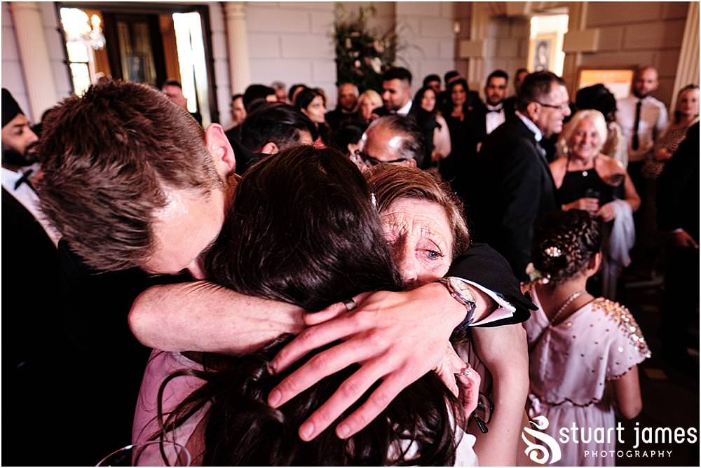 Brides family hug the Bride at Davenport House in Shropshire by Davenport House Wedding Photographers Stuart James