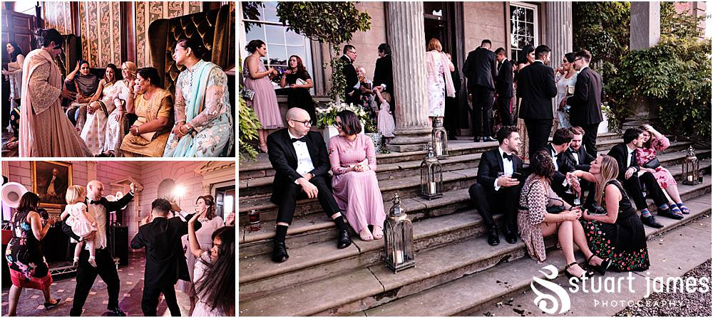 Wedding guests sitting, dancing and talking inside and outside at Davenport House in Shropshire by Davenport House Wedding Photographers Stuart James