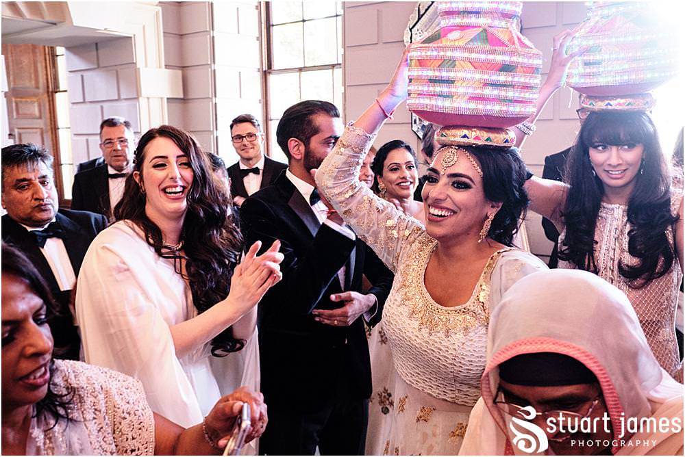 Wedding guests carrying out a Asian wedding tradition at Davenport House in Shropshire by Davenport House Wedding Photographers Stuart James