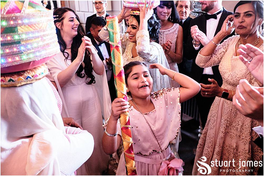 Wedding guests carrying out a Asian wedding tradition at Davenport House in Shropshire by Davenport House Wedding Photographers Stuart James
