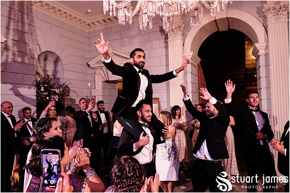 Groom on mans shoulders whilst wedding guests dancing at Davenport House in Shropshire by Davenport House Wedding Photographers Stuart James