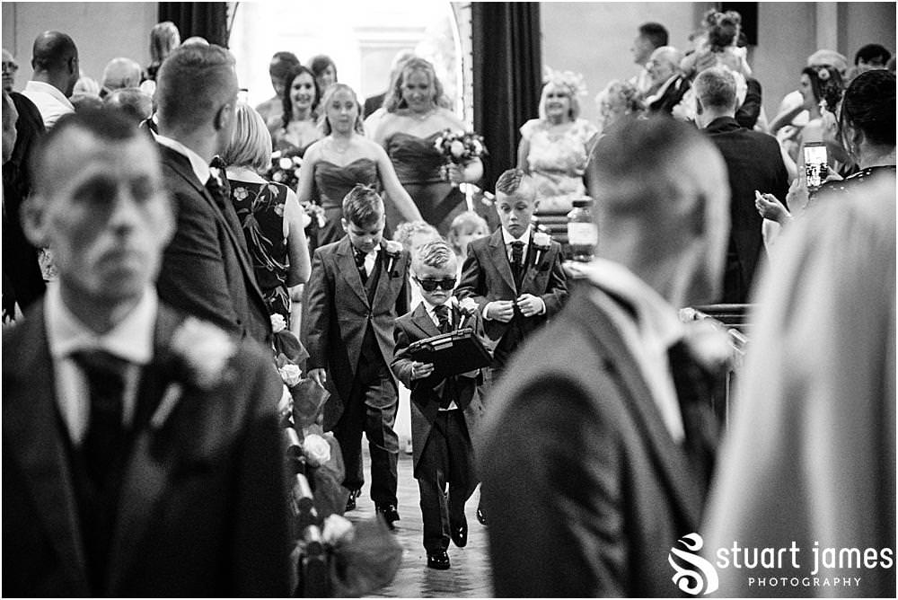 Page Boys and Bridesmaids enter Holy Trinity Church in Eccleshall before the Bride, photo by Stuart James Photography at Holy Trinity Church, Eccleshall