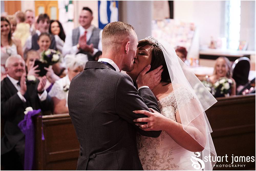 Bride and Groom kiss after being pronounced as married at Holy Trinity Church in Eccleshall, photo by Stuart James Photography at Holy Trinity Church, Eccleshall