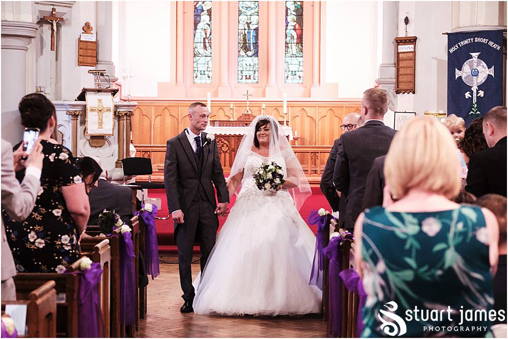 Bride and Groom leave church as a married couple as wedding guests look on at Holy Trinity Church in Eccleshall, photo by Stuart James Photography at Holy Trinity Church, Eccleshall