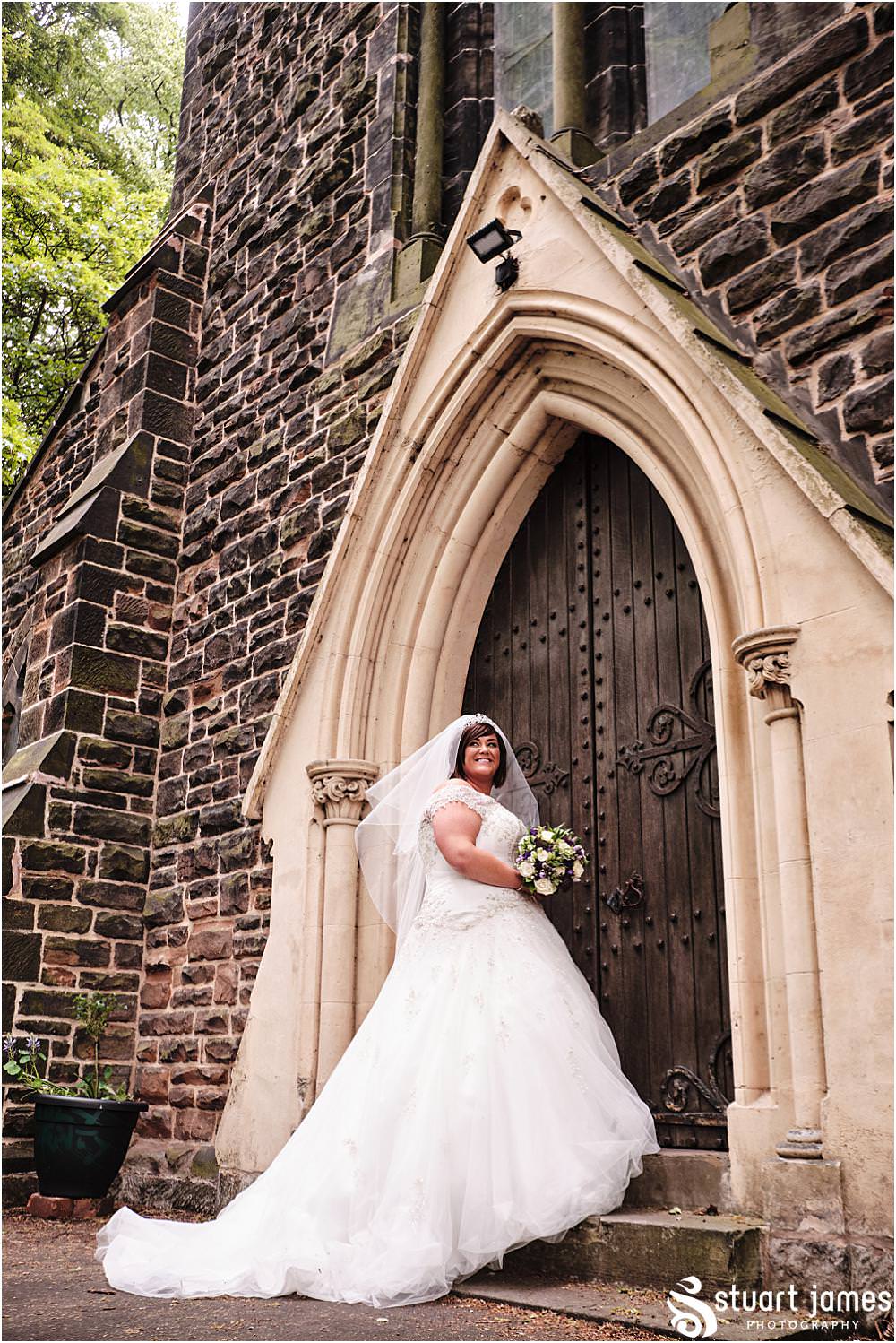 Bride poses for outside portrait at Holy Trinity Church in Eccleshall, photo by Stuart James Photography at Holy Trinity Church, Eccleshall