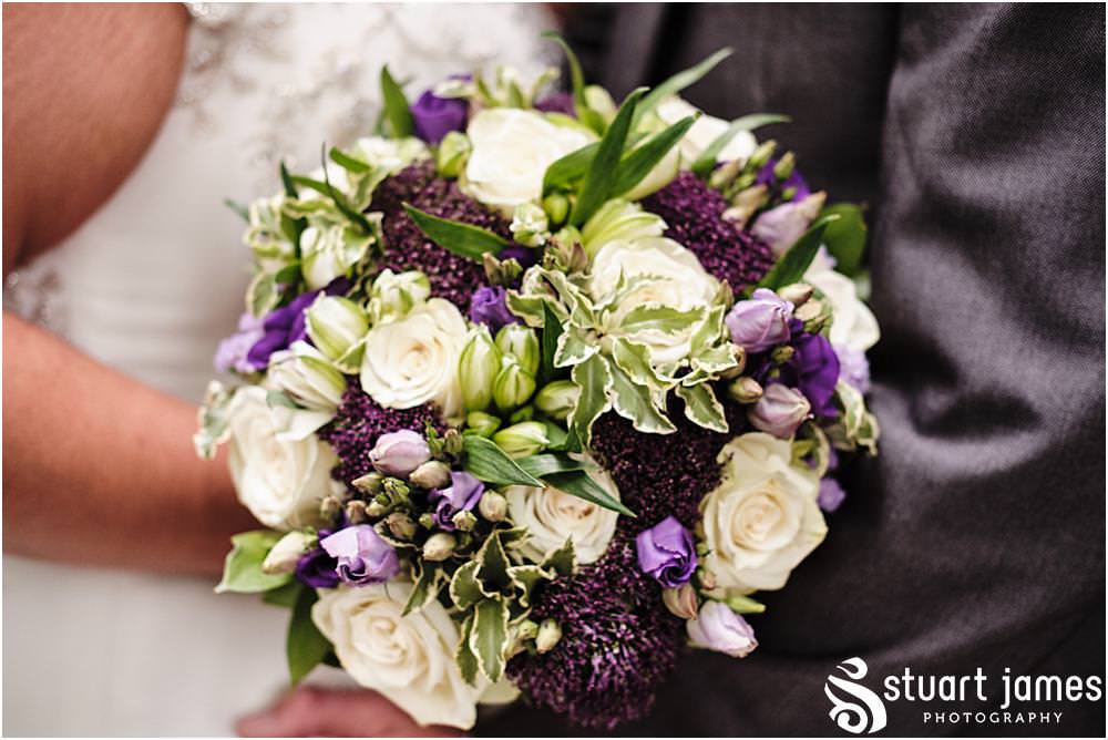 Bride with bridal bouquet of cream roses and purple flowers at Holy Trinity Church in Eccleshall, photo by Stuart James Photography at Holy Trinity Church, Eccleshall