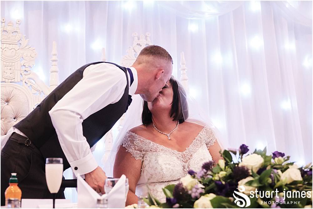 Groom kisses his wife at the top table at The Village Hotel, Walsall, photo by Stuart James Photography